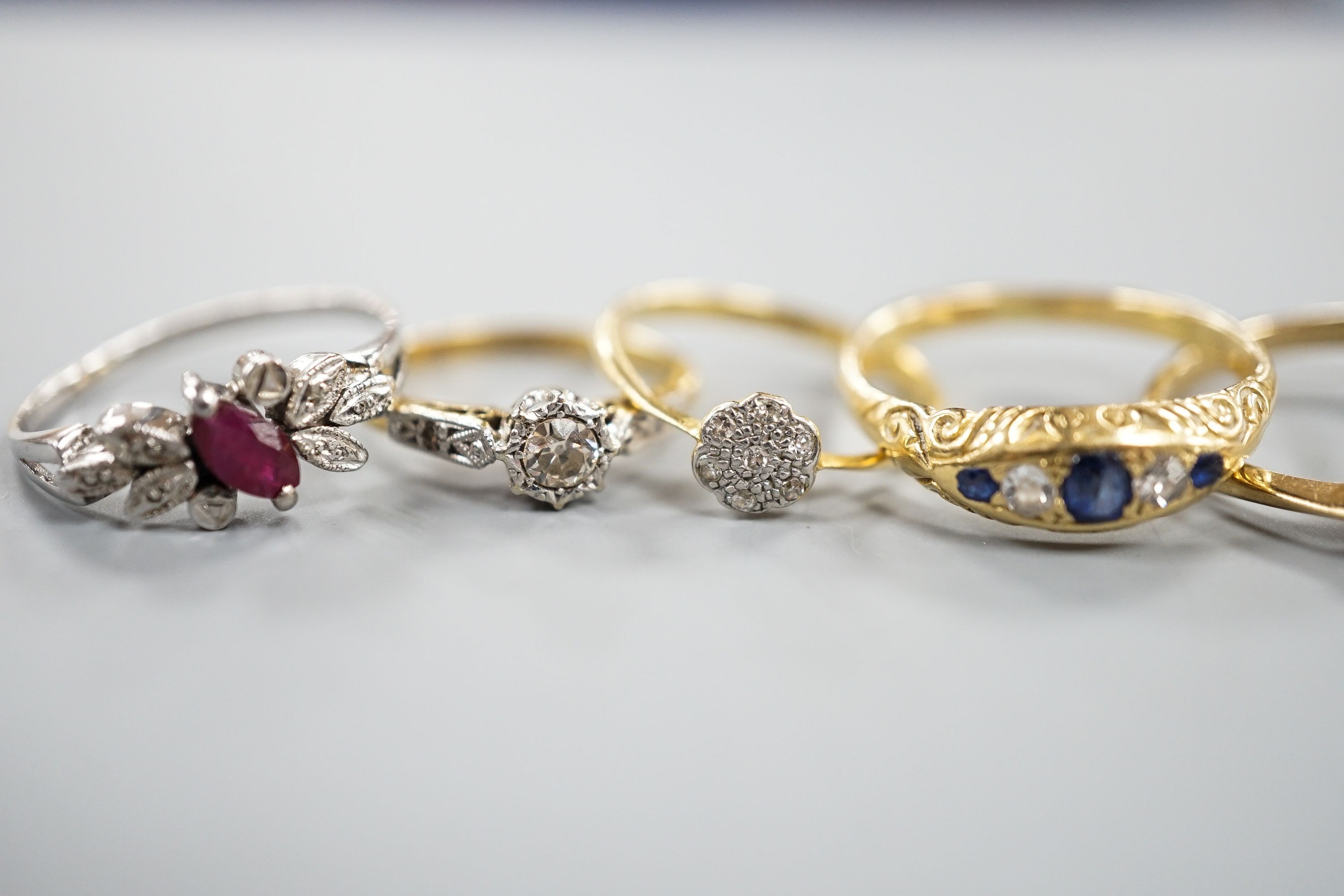 Two 18ct and diamond rings, including small cluster and single stone, sizes L & H, an 18ct sapphire and diamond ring, size O, gross 7.3 grams and two other yellow or white metal and gem set rings, gross 3.6 grams.